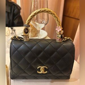 NEW A SPECIAL Chanel Black Mini Bag with charm rings on a gold handle.